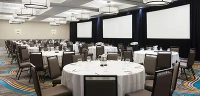 a conference room with tables and chairs with white table cloths at Embassy Suites Denver Tech Center in Centennial