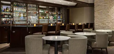 a restaurant with tables and chairs and a bar at Embassy Suites Denver Tech Center in Centennial
