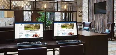 two computer monitors sitting on top of a desk at Embassy Suites Denver Tech Center in Centennial