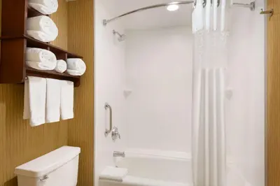a bathroom with a shower and a toilet and towels at Hampton Inn Denver West Federal Center in Lakewood
