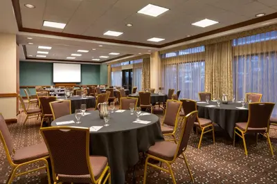 a conference room with tables and chairs and a screen at Hampton Inn Denver West Federal Center in Lakewood