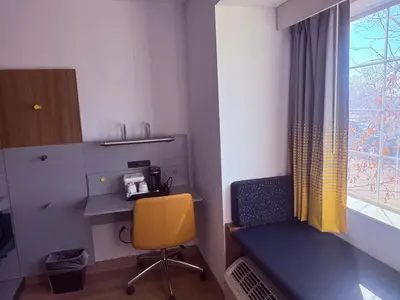 a room with a desk and a chair and a window at Microtel Inn & Suites by Wyndham Denver Airport in Denver