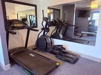 a room with three exercise bikes and a mirror at Microtel Inn & Suites by Wyndham Denver Airport in Denver