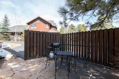 a patio with a fence with chairs and a grill at Wild Flower - EV #3197 in Estes Park