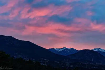 a sunset over a mountain range with snow covered mountains at Wild Flower - EV #3197 in Estes Park