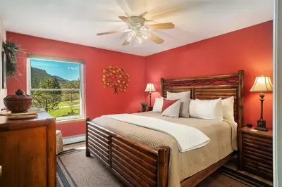 a bedroom with a bed with red walls and a window at Aspen Grove Getaway - EV #3196 in Estes Park