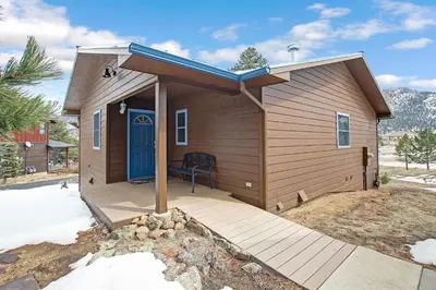 a small house with a blue door on a deck at Aspen Grove Getaway - EV #3196 in Estes Park