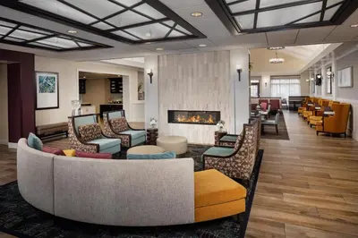 a lobby with couches and chairs and a fireplace at Homewood Suites by Hilton Denver International Airport in Denver