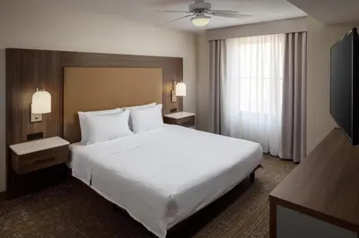 a hotel room with a large bed and a television at Homewood Suites by Hilton Denver International Airport in Denver