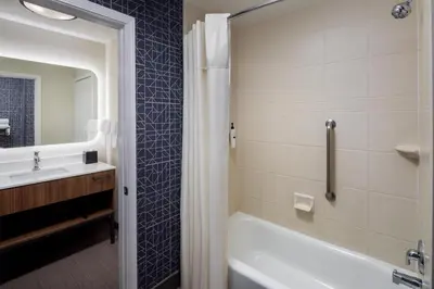 a bathroom with a tub and a sink at Homewood Suites by Hilton Denver International Airport in Denver