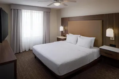 a hotel room with a white bed and a window at Homewood Suites by Hilton Denver International Airport in Denver