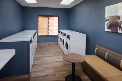 a waiting room with a row of machines in a blue wall at Homewood Suites by Hilton Denver International Airport in Denver