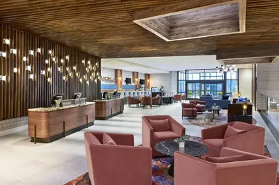 a lobby of a hotel with chairs and tables at Delta Hotels by Marriott Denver Thornton in Westminster