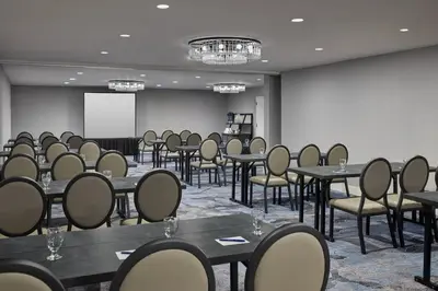 a conference room with tables and chairs and a screen at Delta Hotels by Marriott Denver Thornton in Westminster