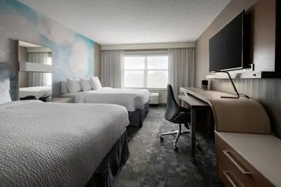 a hotel room with two beds and a desk at Courtyard Denver Airport at Gateway Park in Denver