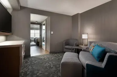 a hotel room with a couch and a television at Courtyard Denver Airport at Gateway Park in Denver