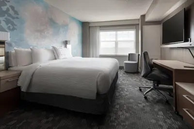 a hotel room with a large bed and a desk at Courtyard Denver Airport at Gateway Park in Denver