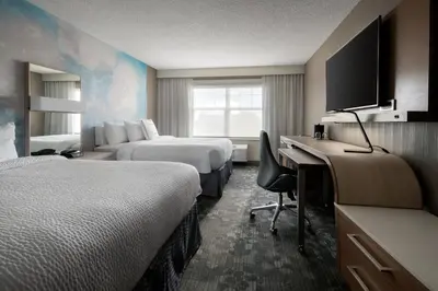 a hotel room with two beds and a desk at Courtyard Denver Airport at Gateway Park in Denver