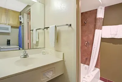 a bathroom with a sink and a mirror at Super 8 by Wyndham Wheat Ridge/Denver West in Wheat Ridge