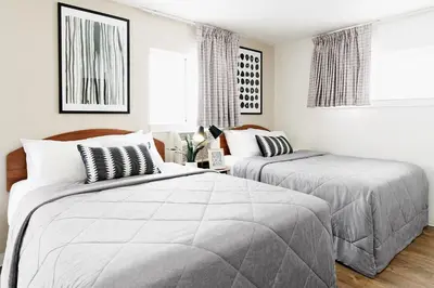 two beds in a bedroom with white walls at InTown Suites Extended Stay Select Denver - Aurora South in Aurora