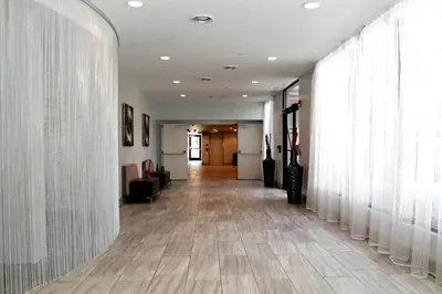 a hallway with white curtains and a long hallway at Plaza Hotel Denver Central in Denver
