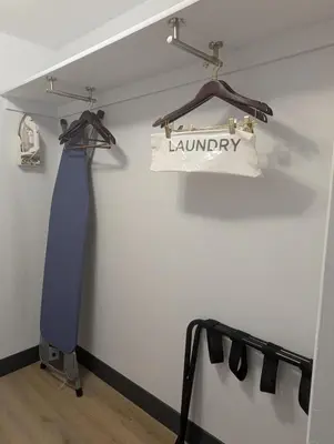 a tie hanging on a wall with a laundry bag at Plaza Hotel Denver Central in Denver