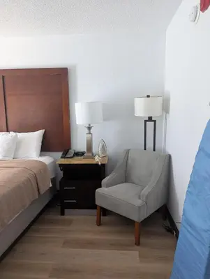 a bedroom with a bed and a chair and a desk at Plaza Hotel Denver Central in Denver