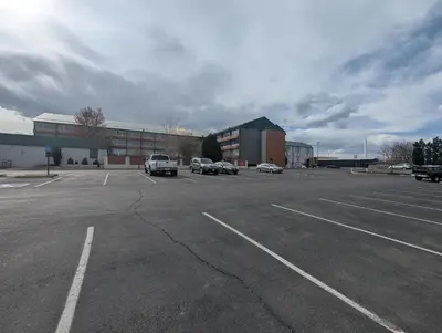 a parking lot with cars parked in front of a building at Plaza Hotel Denver Central in Denver