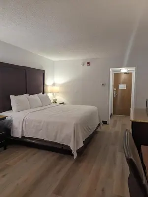 a bedroom with a large bed and a wooden floor at Plaza Hotel Denver Central in Denver