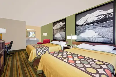 a hotel room with two beds and a flat screen tv at Super 8 by Wyndham Denver Central in Denver