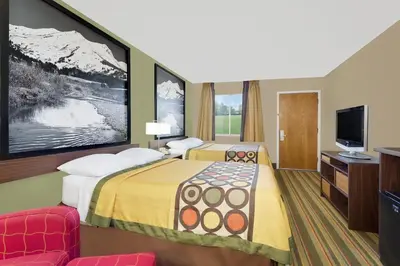 a hotel room with a bed and a tv at Super 8 by Wyndham Denver Central in Denver
