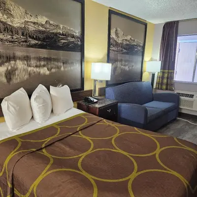 a hotel room with a bed and a couch at Super 8 by Wyndham Denver Central in Denver