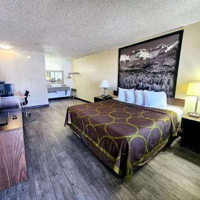 a hotel room with a large bed and a bathroom at Super 8 by Wyndham Denver Central in Denver