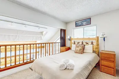 a bedroom with a bed with two white shoes on it at 4 Bed 4 Bath Studio Apartment in Fraser in Fraser