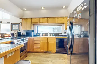 a kitchen with wooden cabinets and a refrigerator at 4 Bed 4 Bath Studio Apartment in Fraser in Fraser