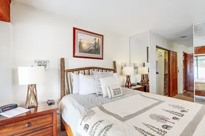 a bedroom with a bed and a desk and a mirror at 4 Bed 4 Bath Studio Apartment in Fraser in Fraser