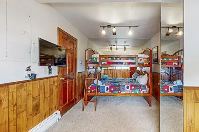 a room with two bunk beds and a kitchen at 4 Bed 4 Bath Studio Apartment in Fraser in Fraser