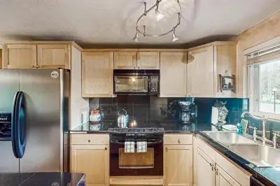 a kitchen with wooden cabinets and a stainless steel refrigerator at Beaver Village in Winter Park
