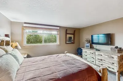 a bedroom with a bed and a flat screen tv at Beaver Village in Winter Park