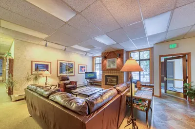 a living room with a leather couch and a table at Beaver Village in Winter Park