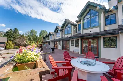 a patio with red chairs and a table and a building at Appenzell Inn in Estes Park