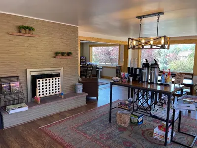 a living room with a fireplace and a dining room at Appenzell Inn in Estes Park