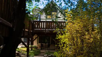 a house with a deck in the middle of a yard at Appenzell Inn in Estes Park