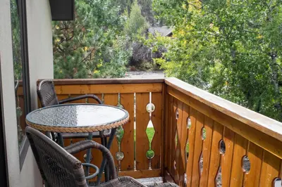 a table and chairs on a balcony with a window at Silver Moon Inn in Estes Park