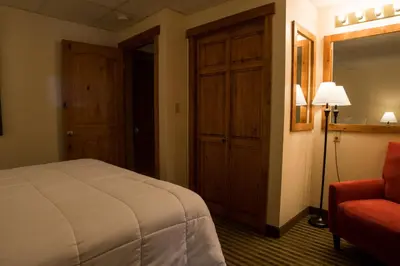 a hotel room with a bed and a red chair at Silver Moon Inn in Estes Park