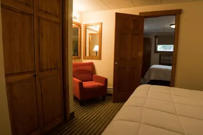 a bedroom with a bed and a chair in a room at Silver Moon Inn in Estes Park