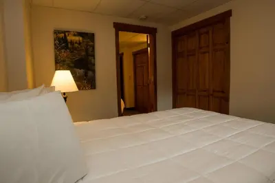 a bedroom with a large white bed and a lamp at Silver Moon Inn in Estes Park