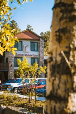 a building with cars parked in a parking lot at Silver Moon Inn in Estes Park