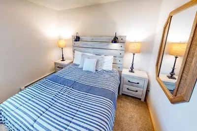 a bedroom with a bed with a blue and white striped blanket at Timber Ridge 203 in Silverthorne