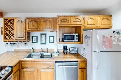 a kitchen with wooden cabinets and a white refrigerator at Timber Ridge 203 in Silverthorne